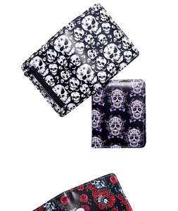 Three gothic style short wallets with skull and rose prints on a clean white background