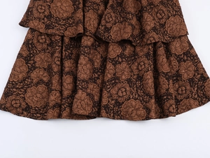Détail du tissu jacquard floral marron avec ourlet à volants superposés de style rétro