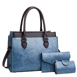 Three-piece set of blue faux leather shoulder bags including tote, clutch, and card holder