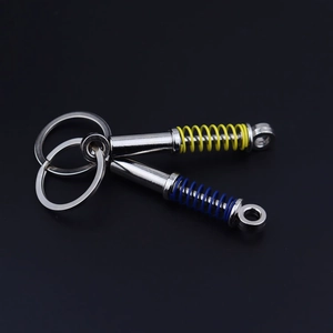 Detailed view of metal car shock absorber keychains in vibrant yellow and blue colors