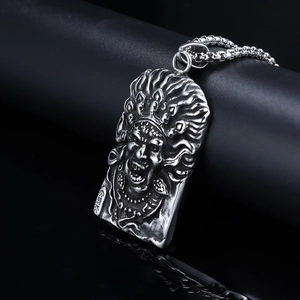 Vintage stainless steel necklace with 3D relief deity pendant on a black surface