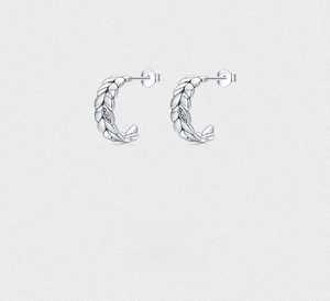 Macro shot of S925 sterling silver leaf stud earrings featuring small inset crystals