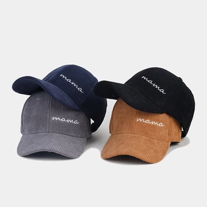 Detailed view of corduroy baseball caps in navy, black, grey and brown with mama embroidery