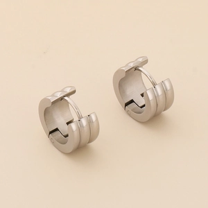 Detailed close-up of triple-row ridged huggie earrings in matte silver titanium steel