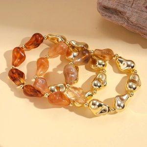 Bohemian acrylic irregular bead bracelets with gold metal accents on warm background