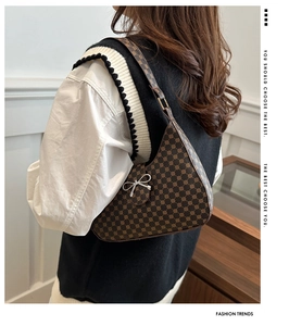 Detail showing vintage brown dot-pattern hobo bag with a silver metal bow accent