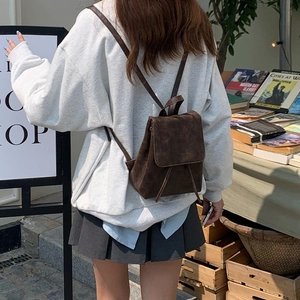 Dettaglio di mini zaino marrone vintage con trama opaca e chiusura a patta classica