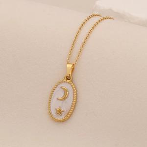Detailed close-up of a gold oval pendant featuring celestial moon and star designs