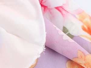 Close-up detail of floral print fabric with purple base and professional stitching edge