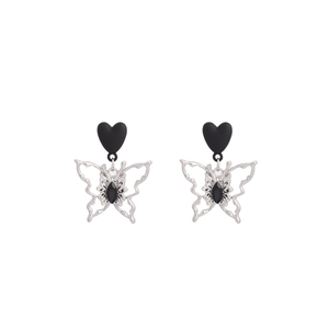 Détail du clou d'oreille cœur mat noir avec pendentif papillon argenté et strass