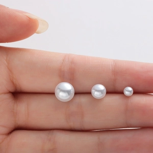 Minimalist S999 sterling silver pearl studs in three sizes shown on fingers