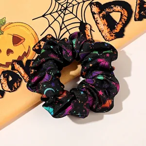 Close-up of black Halloween scrunchie with purple bats and stars on festive background