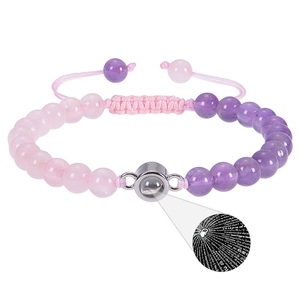 Detail eines Perlenarmbands mit Projektion von Ich liebe dich in 100 Sprachen unter Lupe