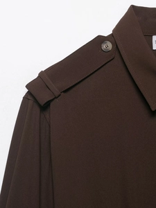 Detailed view of dark brown woven shirt shoulder featuring epaulet with a resin button