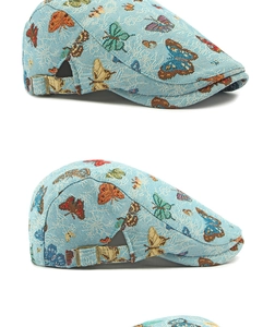 Detail view of butterfly jacquard newsboy cap with adjustable bronze metal buckle
