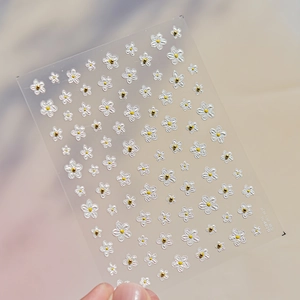 Detail of TO 4870 nail sticker with white flowers and golden accents on clear base