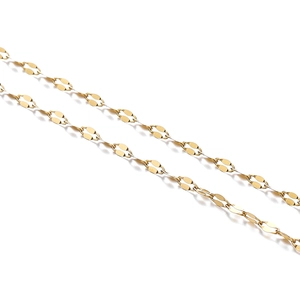 Detailed close-up of golden stainless steel curb chain with flat oval links on white