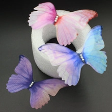 Détail de broches papillon en tulle avec perles en rose, bleu et nuances de violet