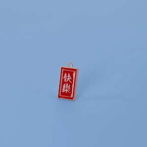 Détail d'un pendentif en émail rouge avec caractères chinois blancs pour le bonheur