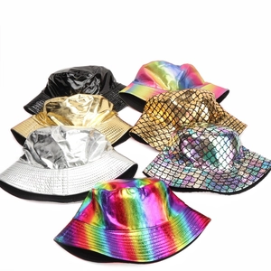 Detailed flat lay of glossy faux leather bucket hats in silver, gold, and iridescent scales