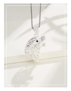 Macro view of S925 sterling silver wolf head pendant with red gemstone eyes and chain