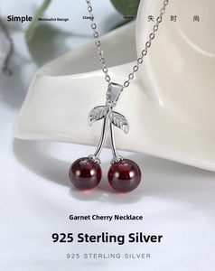 Macro close-up of S925 sterling silver cherry pendant with dark red garnet stones