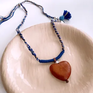 Ethnic wooden heart pendant necklace with colorful woven rope and blue tassels