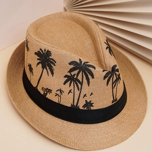 Détail d'un chapeau fedora en paille tressée avec ruban noir et motifs de cocotiers noirs