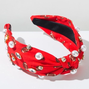 Détail de bandeau rouge à motif rugby orné de perles blanches et de strass brillants
