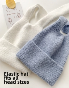 Macro shot showing white and light blue fluffy mohair knit texture on elastic beanies