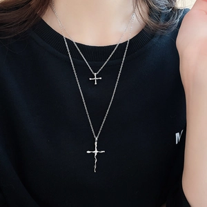 Detail of silver double-layered cross necklace with fluid lava texture on black fabric
