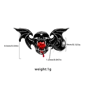 Gothic skull ear stud with red heart gem and bat wings detail in vintage black finish