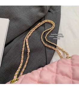 Close-up of pink quilted leather bag with classic gold-tone metal woven chain strap