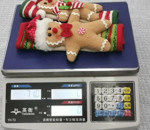 Close-up of gingerbread man refrigerator handle covers with red bows and striped cuffs