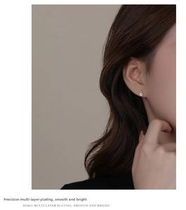 Detailed close-up showing a shiny single zircon earring with multi-layer plating on ear