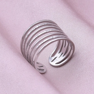 Detailed close-up of multi-layer silver stainless steel ring on pink silk fabric