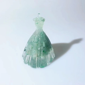 Macro detail of resin wedding dress figurine with green crystals and sparkling glitter