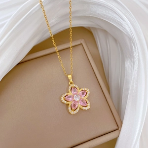 Macro detail of gold flower necklace with pink gemstones and sparkling zircon crystals