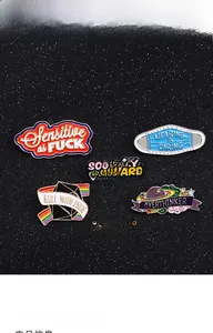 Detailweergave van zes creatieve emaille reversspelden met diverse slogans op zwarte glitter