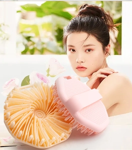 Close-up of pink silicone body scrubber with long bristles and anti-slip handle