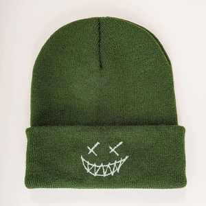 Close-up of military green knit beanie featuring a white embroidered ghost face design
