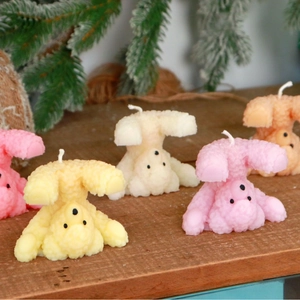 Cute cartoon bear-shaped scented candles in various colors on a rustic wooden table