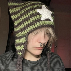 Close-up of handmade striped crochet hat with cat ears and braided tassels