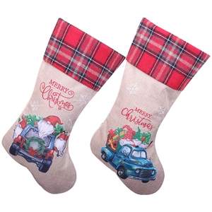Beige linen Christmas stockings featuring Santa driving a blue truck with plaid cuffs