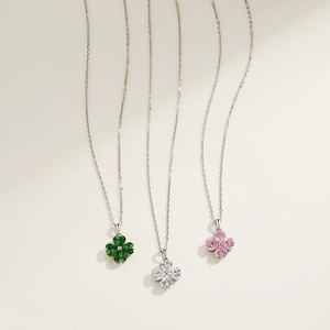 Detail of S925 silver clover necklaces with green, white, and pink heart-shaped zircons