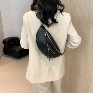 Women's black pebbled leather chest bag with tassel zipper and patterned wide strap