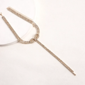 Detailed close-up of gold multi-row rhinestone choker with long Y-shaped tassels