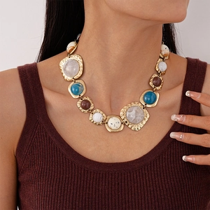 Detailed close-up of retro irregular resin geometric pendants on golden link necklace
