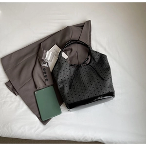 Flat lay of large canvas tote bag with a grey blazer and tablet for professional use