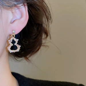 Detail of elegant gold gourd earrings with pink and white crystals on a model